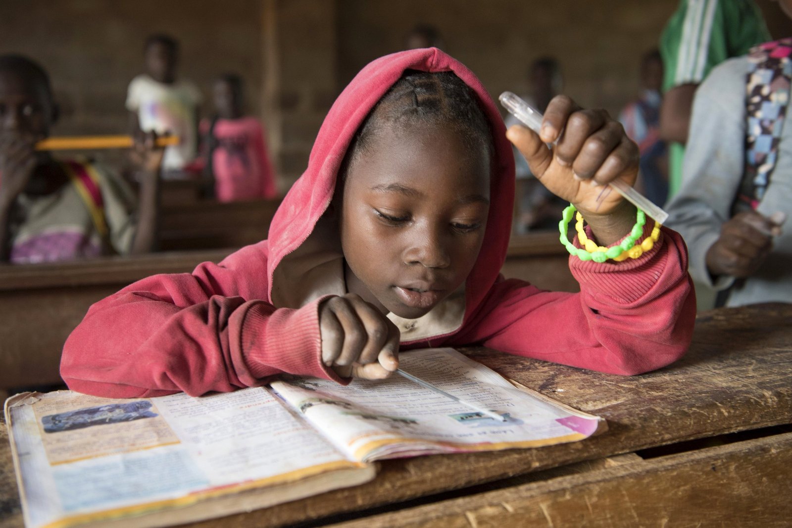 Enfant en train d'apprendre, concentré sur ses cahiers, dans son atelier